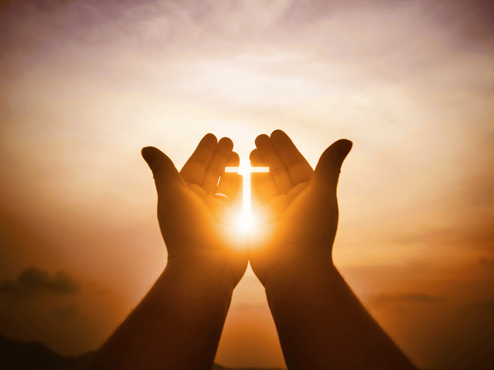 hands with the sun forming a cross