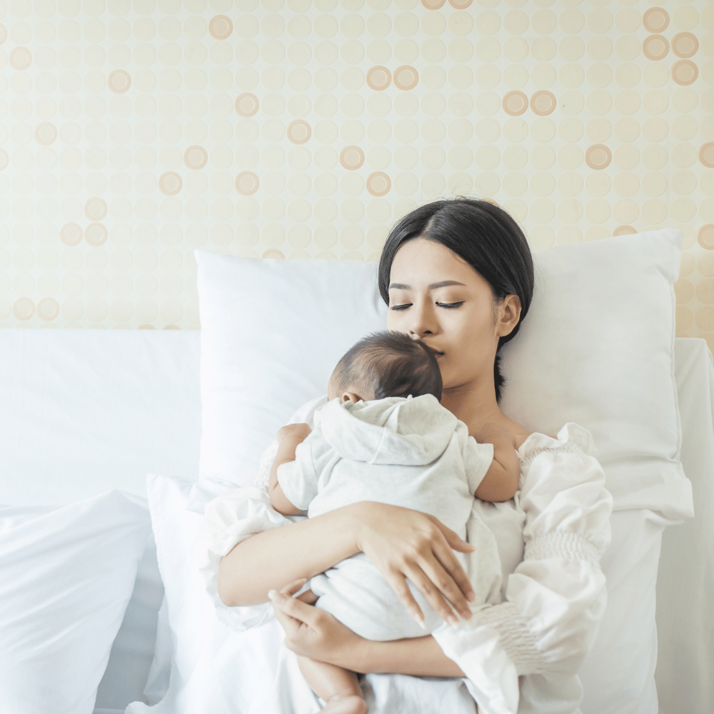 woman snuggling newborn baby