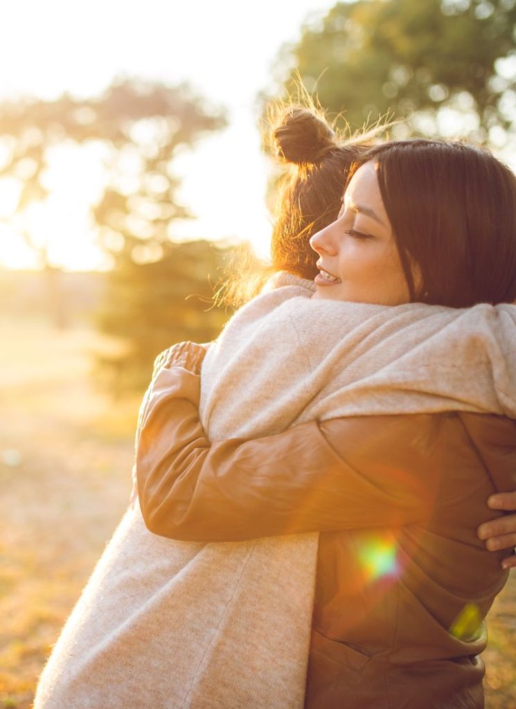 women hugging outside